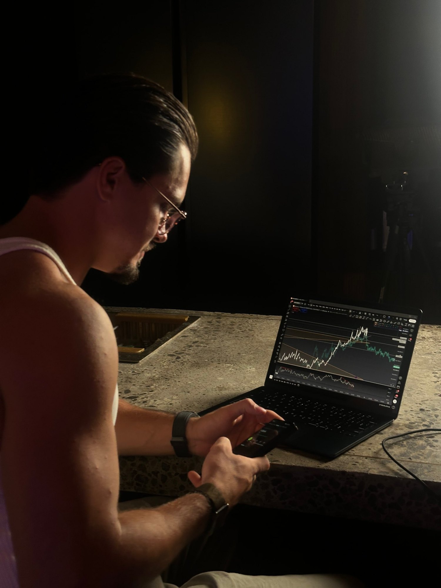 Denis reviewing a trading chart on his laptop